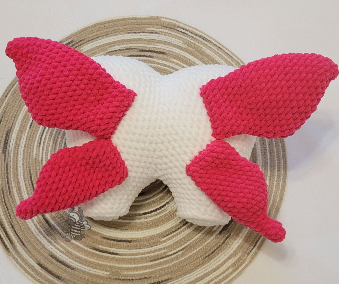 Backside of the tooth fairy pillow showing the pink wings on a wood grain circle and a white background.
