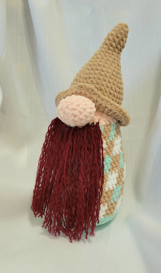 Crocheted gnome with a brown hat and red beard on a light background
