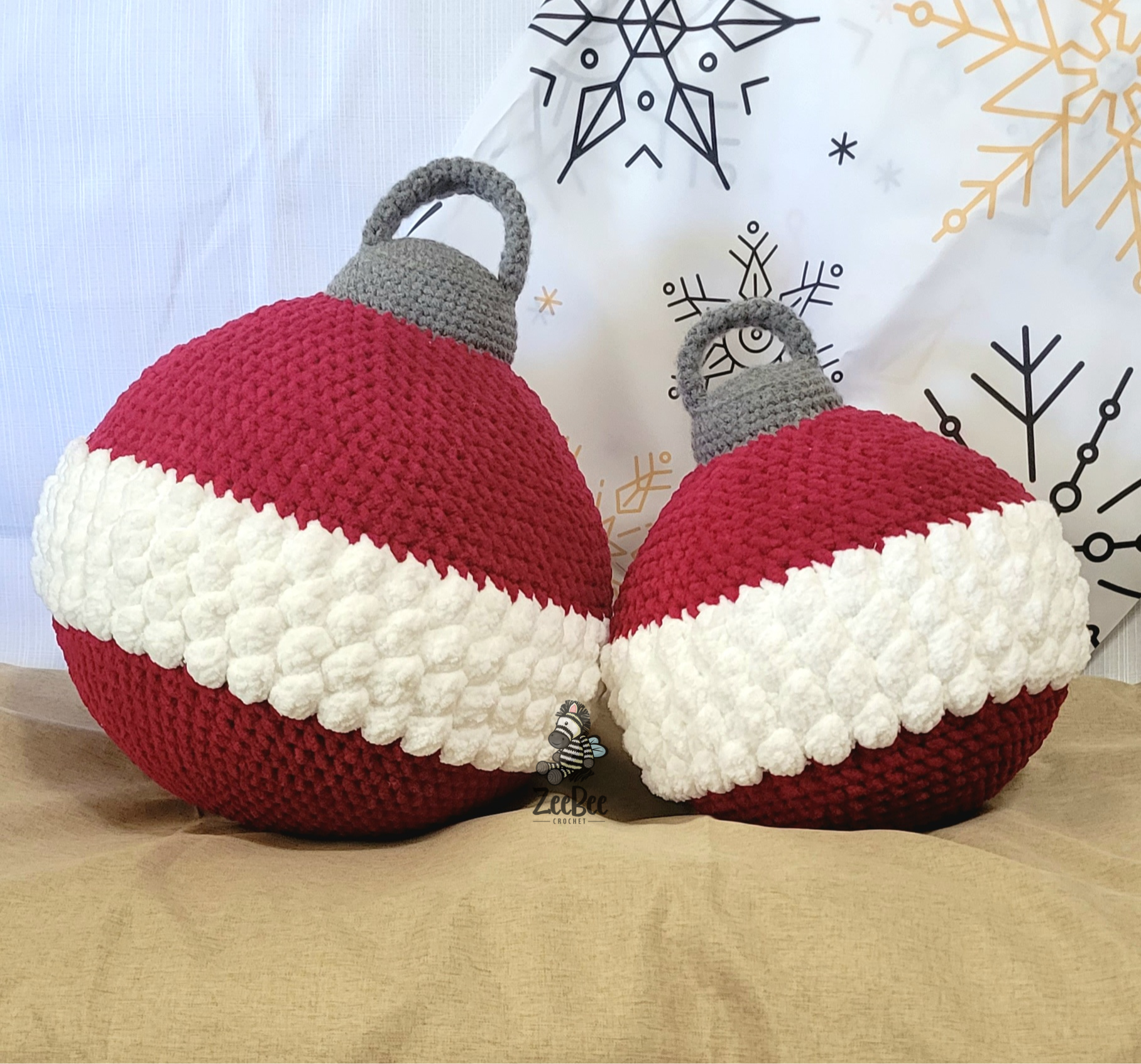 Two crocheted Christmas ornament pillows with red and white stripes on a neutral background.