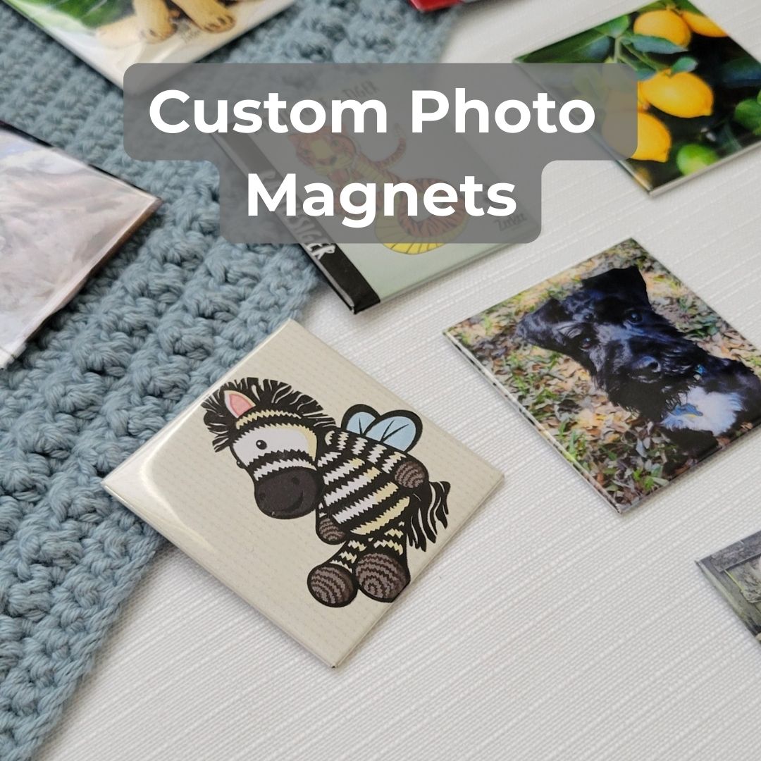 Collection of custom photo magnets on a surface with a Zeebee logo magnet in focus with text above magnets that says custom photo magnets