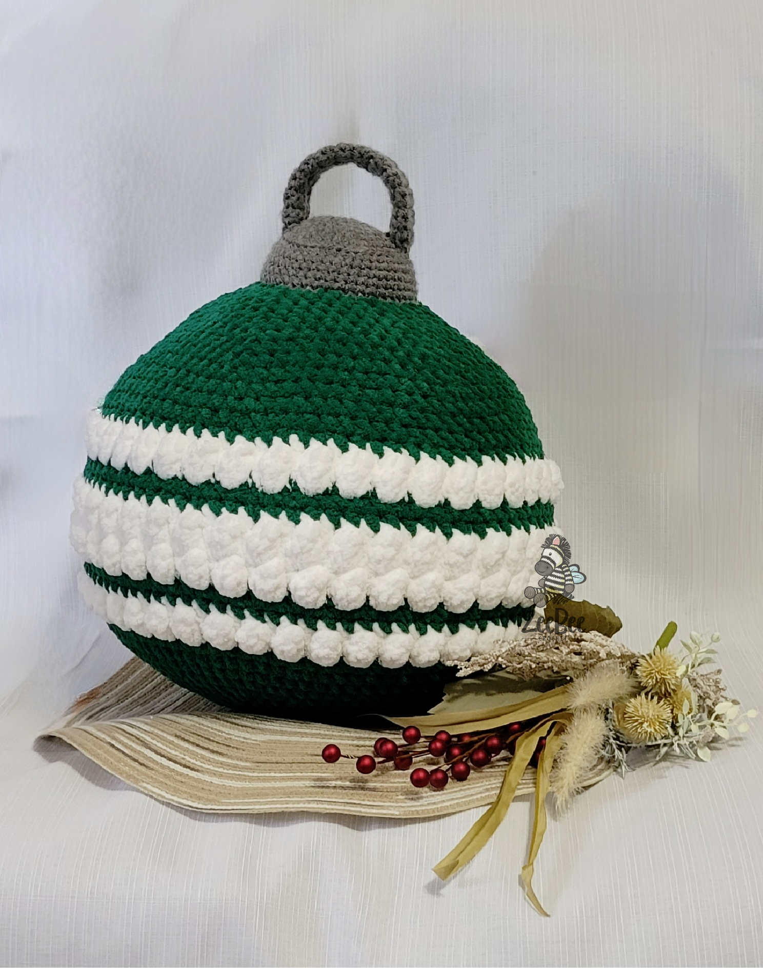Crocheted Jumbo striped ornament pillow with green, white, and gray colors on a white background
